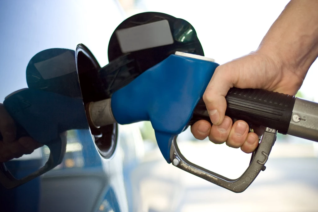 A person fuelling up a car at a station
