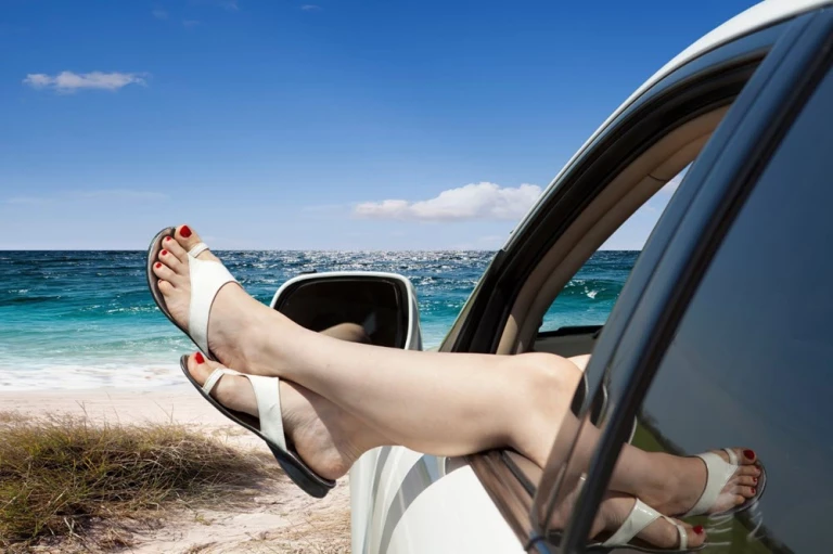 Lady with Feet out of Car Window at Beach
