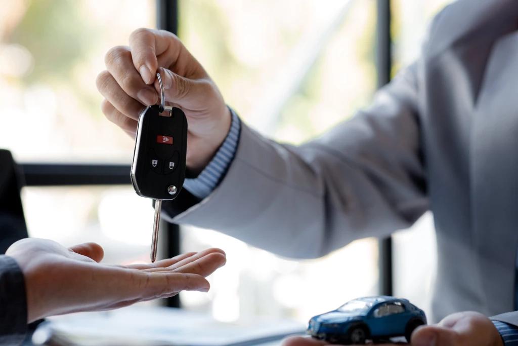 A set of car keys being handed over.