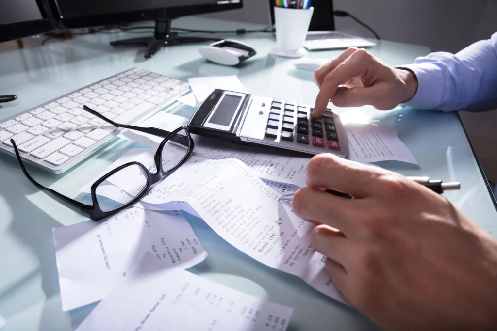 A person calculating their payments on receipts for tax purposes